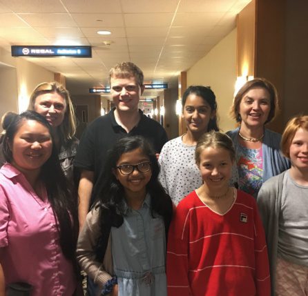 A group of people standing in a hallway.