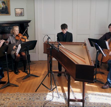 A group of people playing instruments in a room.