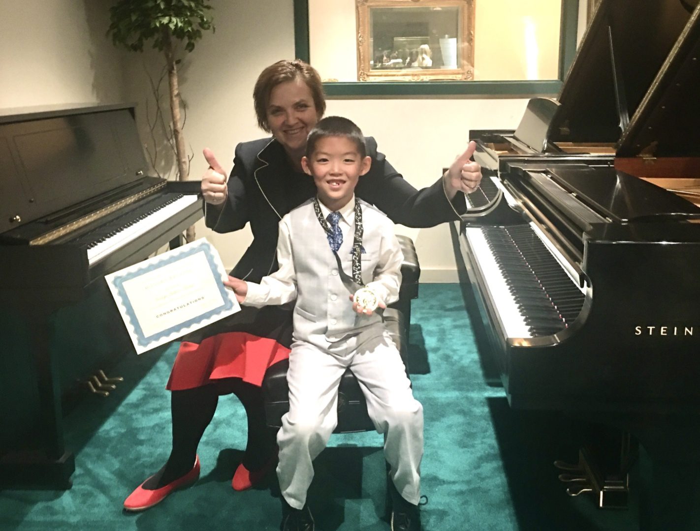 A woman and boy sitting in front of piano