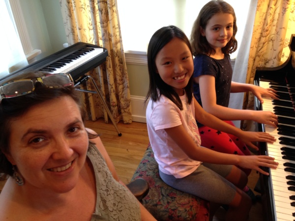 A woman and two girls sitting on the floor