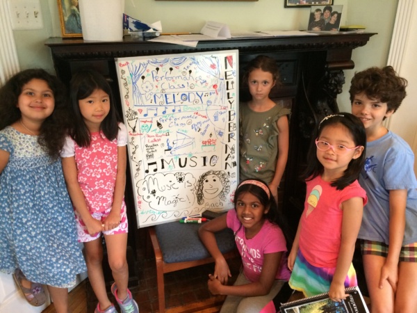 A group of children standing around a poster.