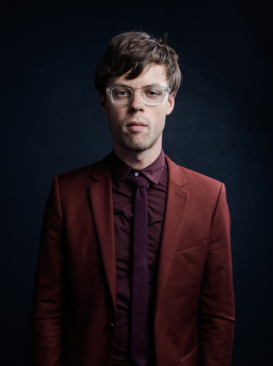 A man in a red suit and purple shirt.