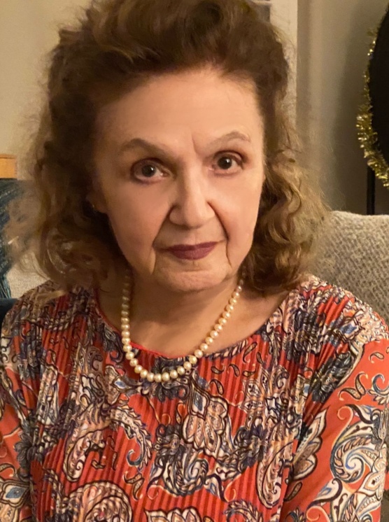 A woman with long hair and a necklace.